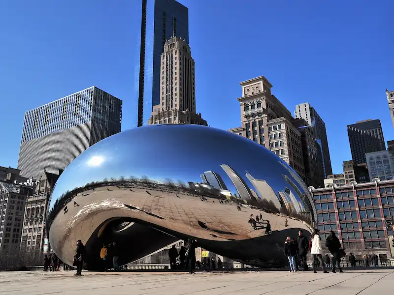 The Cloud Gate sculpture in Millennium Park with the Chicago skyline behind