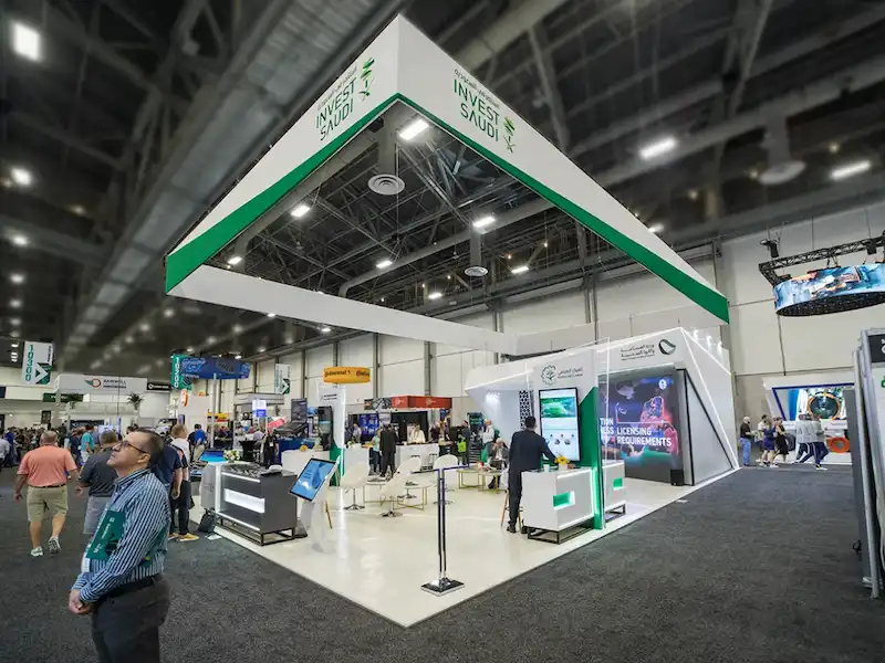 A large custom exhibit stand with a suspended overhead sign on a Chicago show floor