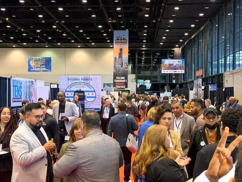 Attendees networking between booths at a Chicago exhibition
