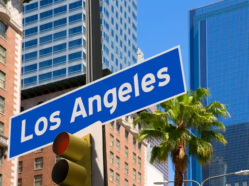 Los Angeles street sign surrounded by downtown buildings and palm trees
