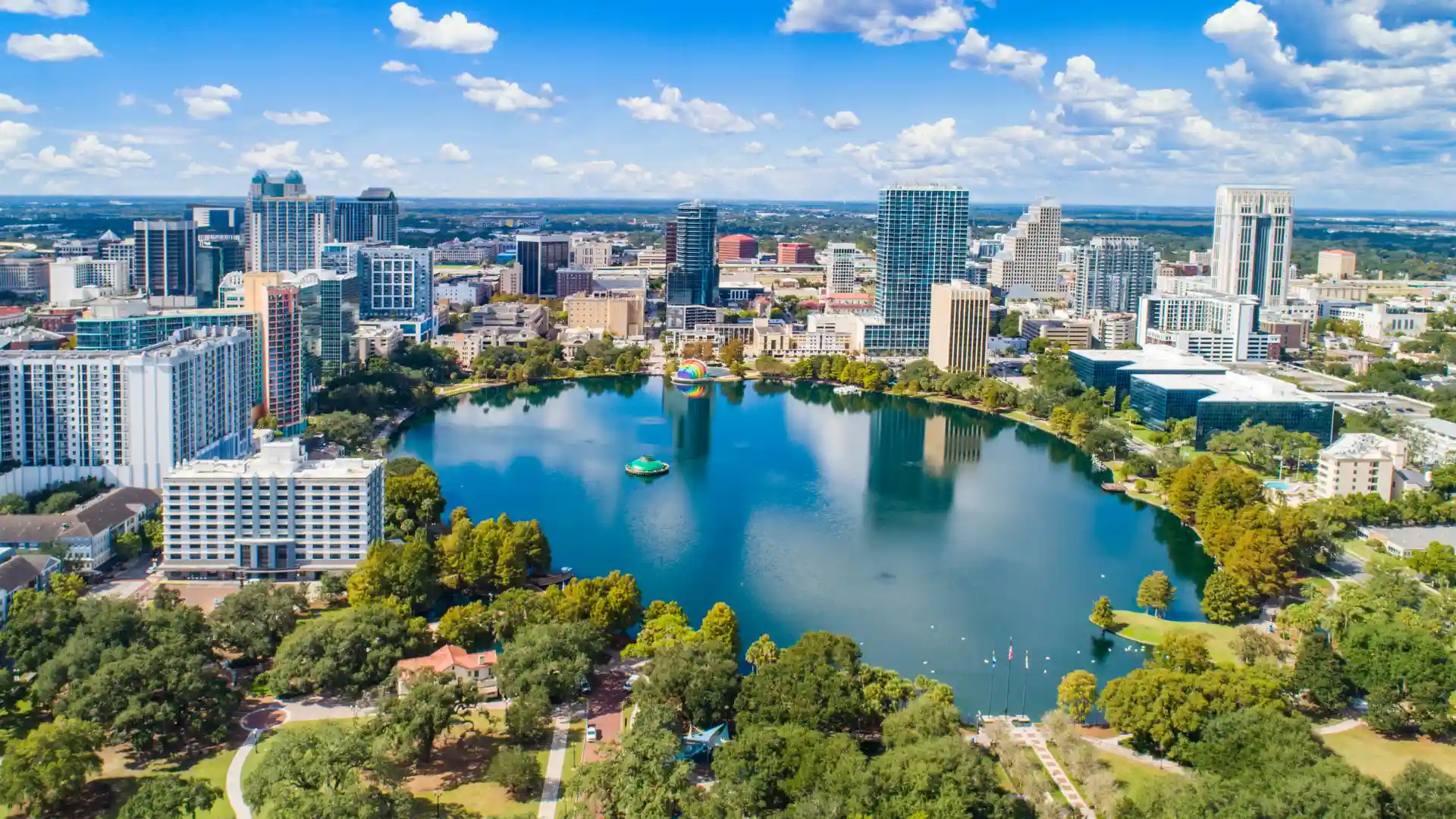 Orlando skyline surrounding Lake Eola with downtown buildings and palm trees